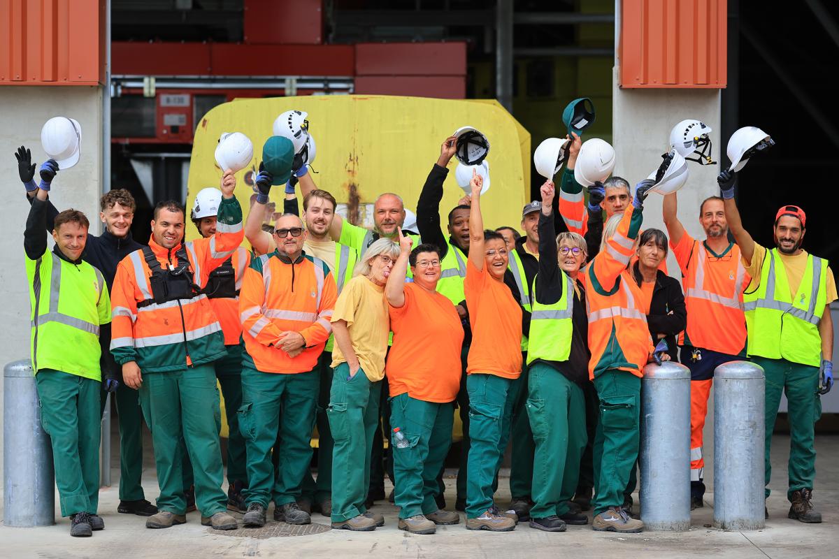 groupe d'agents de Trifyl souriants et bras levés devant l'objectif du photographe
